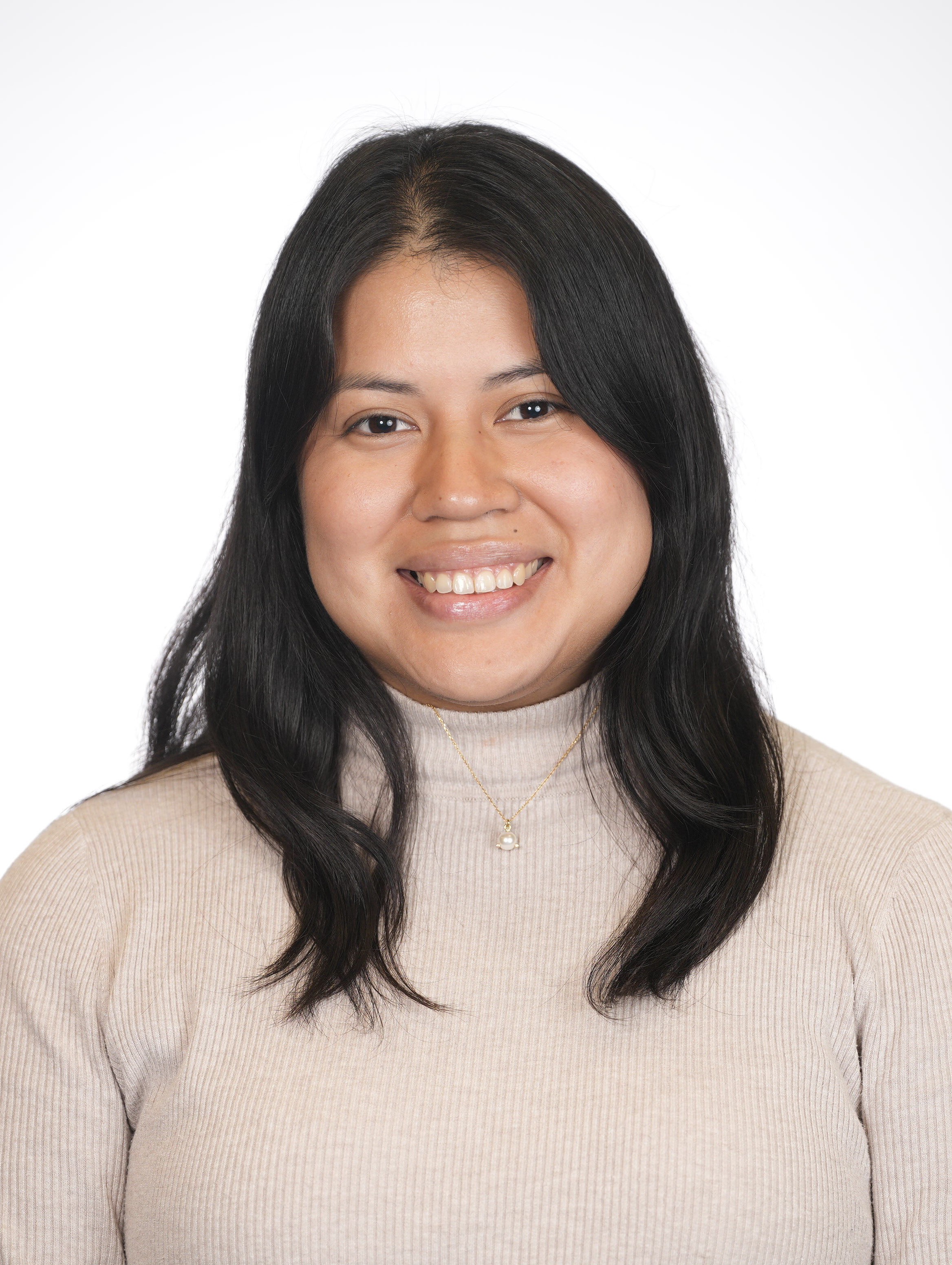 Girl with long black hair smiling in front of white background